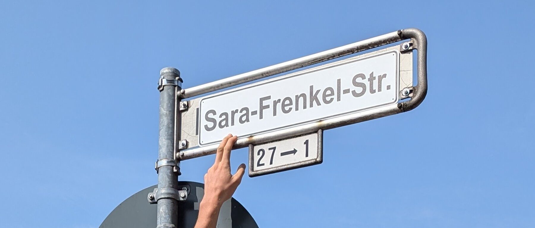 ein mit sara-frenkel-str überdecktes straßenschild